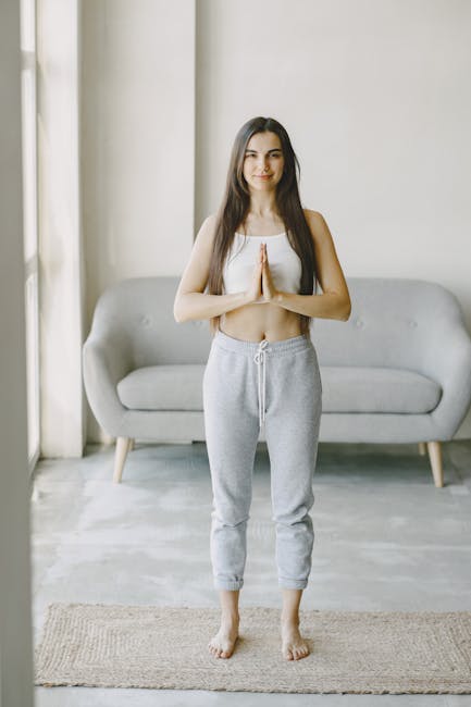 Woman in a comfortable yoga pose at home, serene expression.